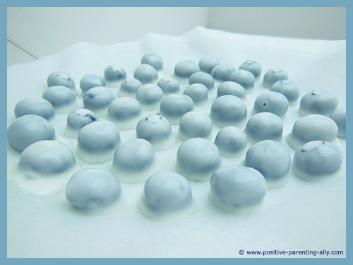 Blueberry snacks covered in yoghurt ready to freeze. 