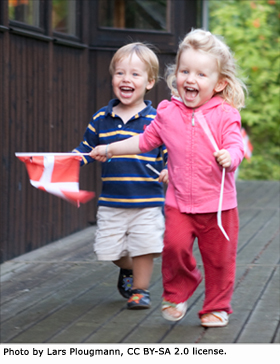 Danish kids running freely with Danish flag in their hands.