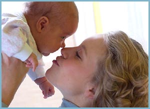 Photo of happy mother kissing her little baby