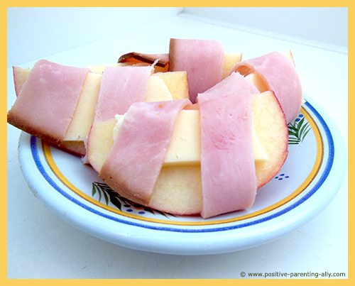 Easy snacks for kids to make in no time: apple and cheese rolled with ham. 