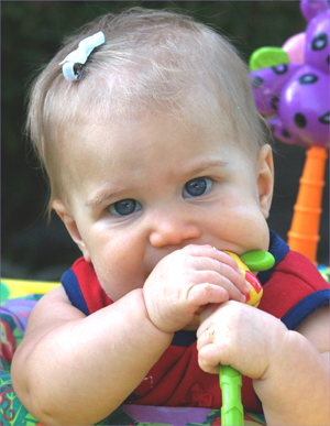 Freud's oral stage featured via a baby sucking and chewing on a rattle.