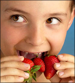 Healthy eating for kids: boy about to eat strawberries