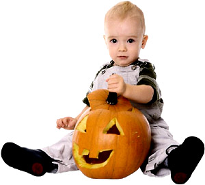 Cute little toddler sitting with a big pumpkin head for Halloween.