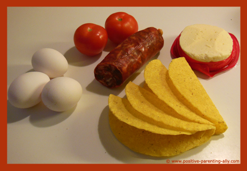 Ingredients for the breakfast taco: Eggs, tomatos, chorizo sausage, cheese and taco shells. 