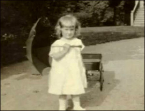 Old photo of Mary Ainsworth as little girl holding an umbrella.