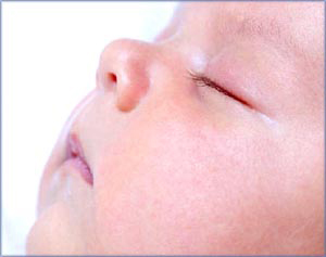 Newborn  sleeping patterns: Sleeping infant in profile, close-up.