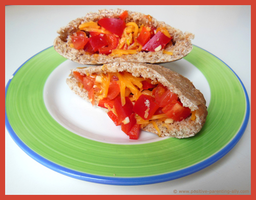 Tasty pita snack for kids with cheese, tomato, bell pepper and garlic. Healthy mini-meal for kids.
