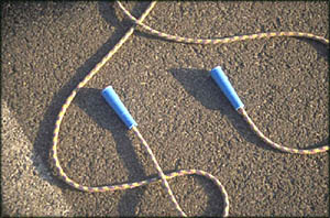 Fun toddler activities for outside: A photo of a jump rope on the pavement.