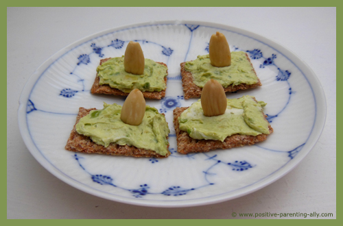 Avocado spread on cracker as healthy snacks for kids.