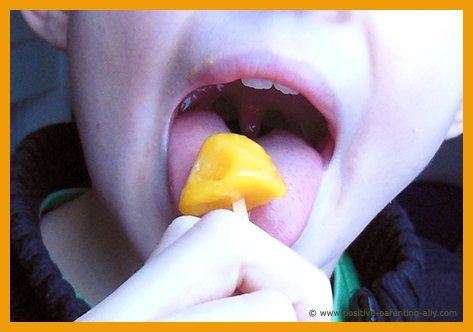 Kid eating healthy mango popsicle. Fruit popsicle recipe.
