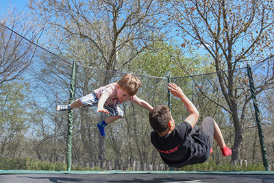 Children jumping on a trampoline.