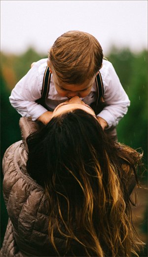 Child and mother bonding with heads close together. 