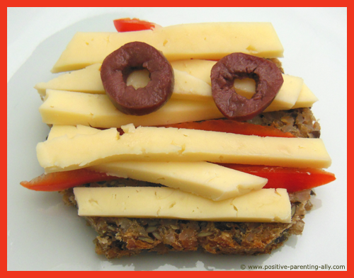 Easy Halloweeen recipes for kids: Funny mummy sandwich with cheese, pepper and olives.