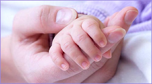 Baby hand holding mom's finger. Picture of hands.