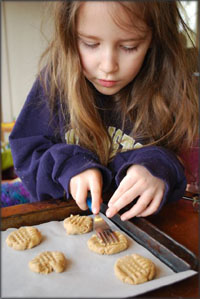 Taking on responsibility. Girl helping out in the kitchen, baking cookies