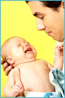 Picture of father holding his crying baby.