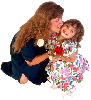 Mother kneeling hugging her little girl. 