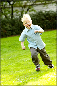 Little boy running on the grass.