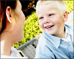 Happy blond boy talking to his mother.