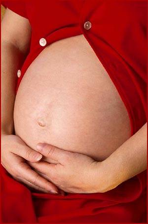 Ethics of surrogacy: picture of pregnant belly. Mother holding her belly. 