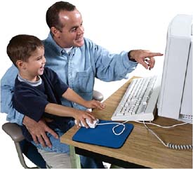 Father and son playing at or working by the computer.