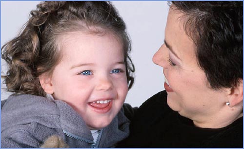 Happy little girl with her mom looking at her.