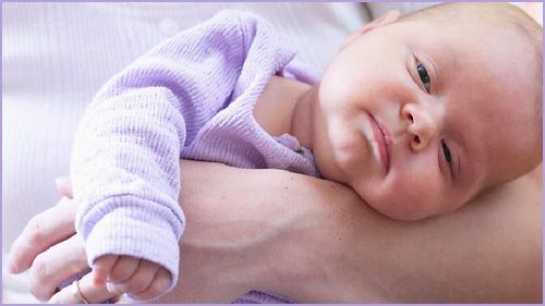 Little baby infant lying on his mother's arm.