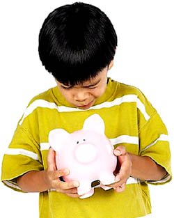 Boy looking into his piggy bank for money.