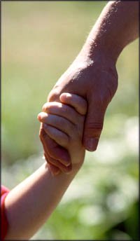 Stages of child development: boy holding his father's hand.